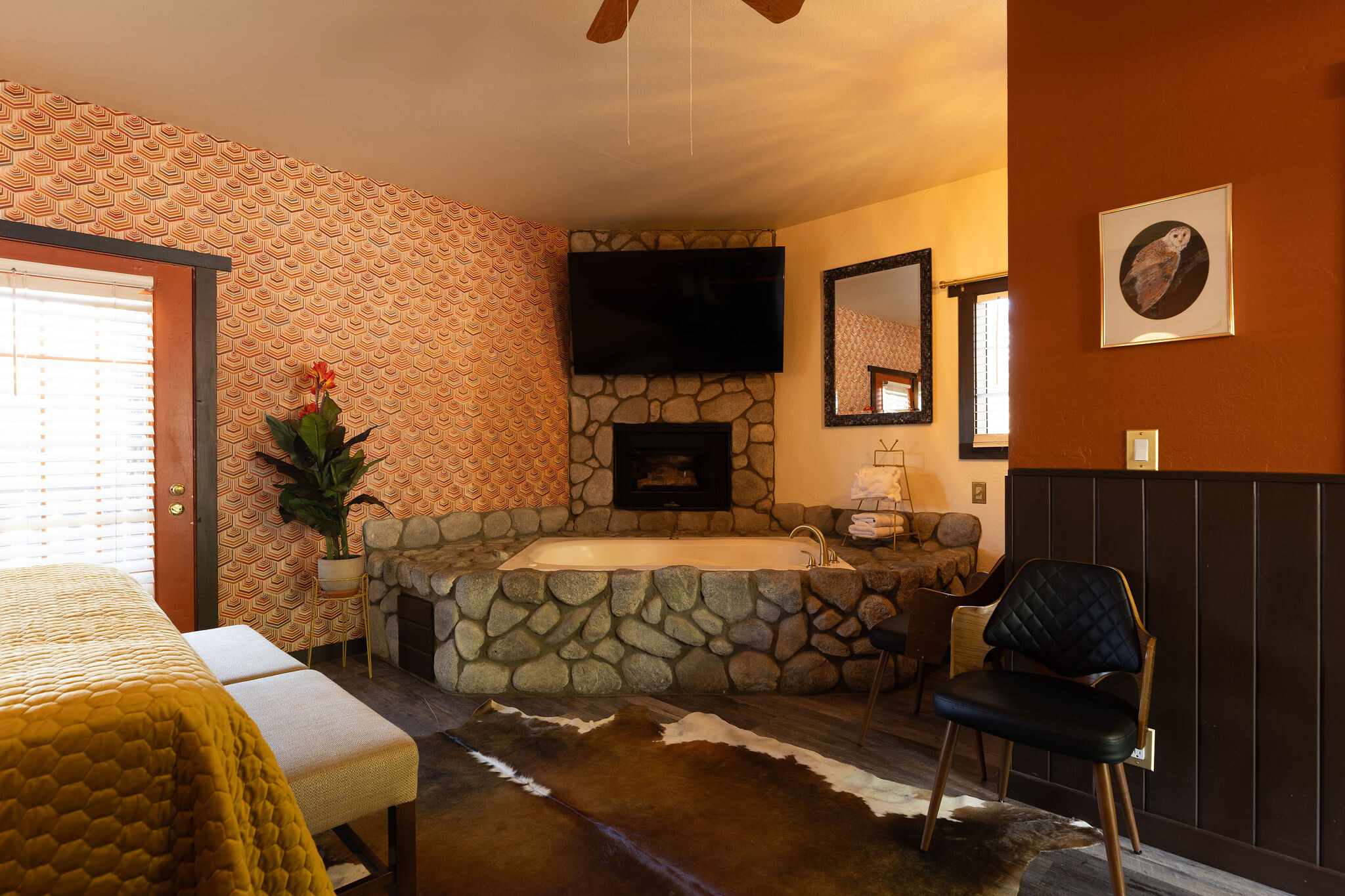 Spa Suite — king bed with jet tub and stacked-stone fireplace