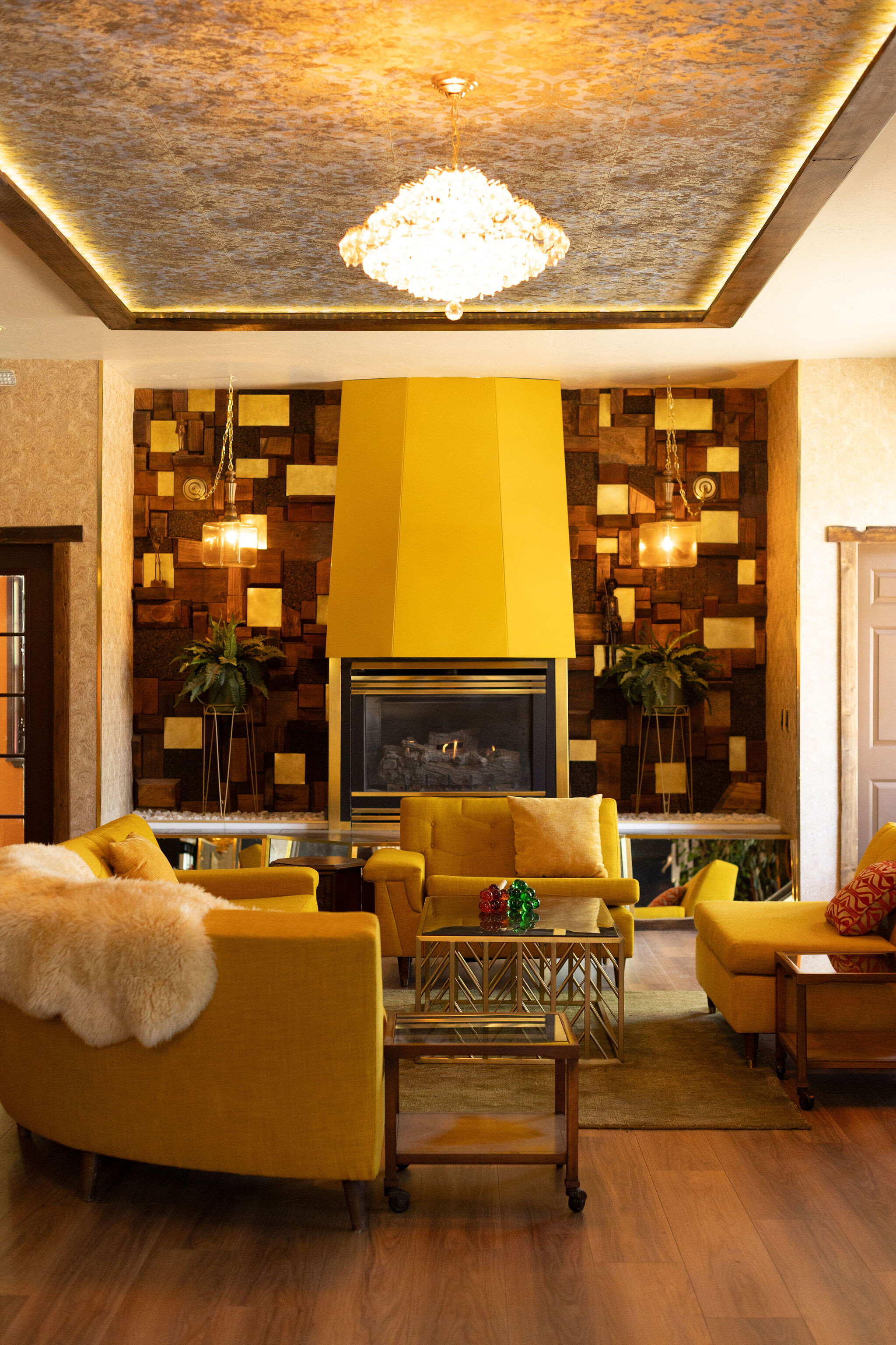 Burgundy lounge with yellow tile fireplace and chesterfield sofa