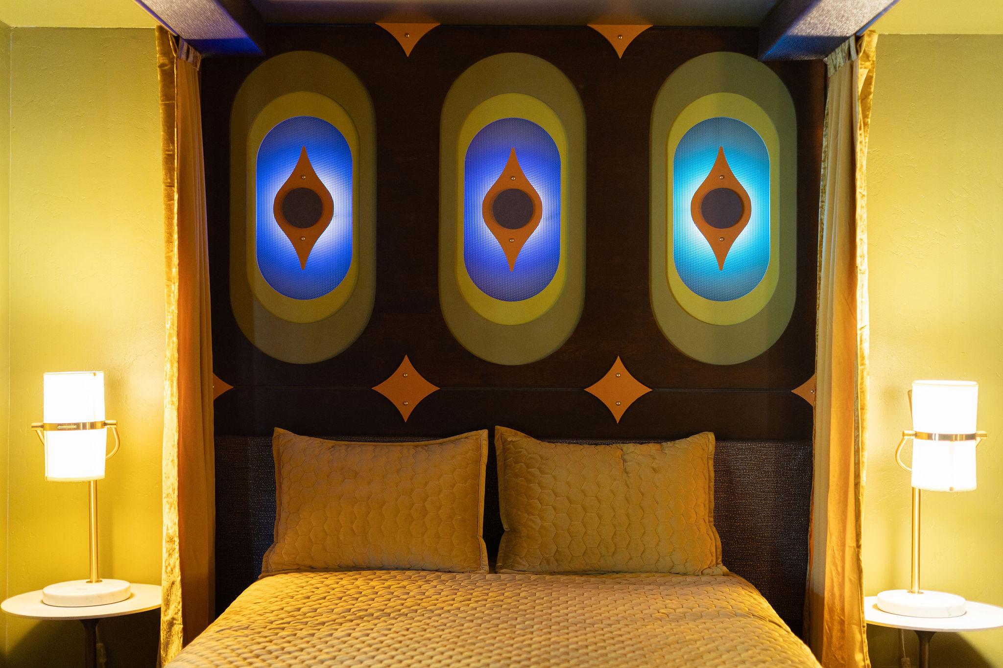 Blue LED-oval eye headboard panels — Main Building signature room